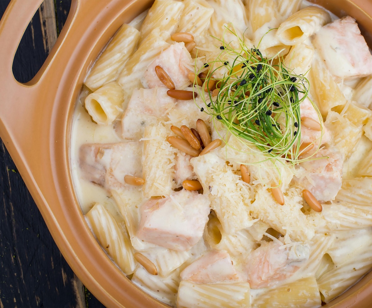 Salmon pasta bowl with crushed walnuts and cilantro garlic paste